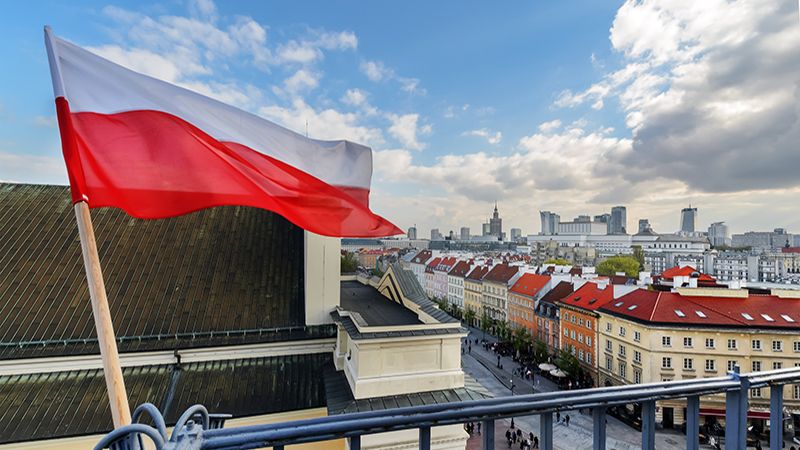 Poland Flag in Blue Sky and the centre of Warsaw in background