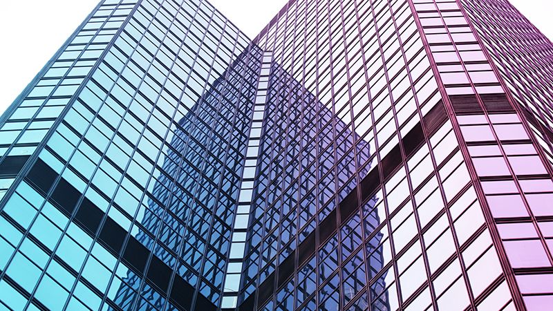 Interesting reflection and lines formed by two modern glass architecture.