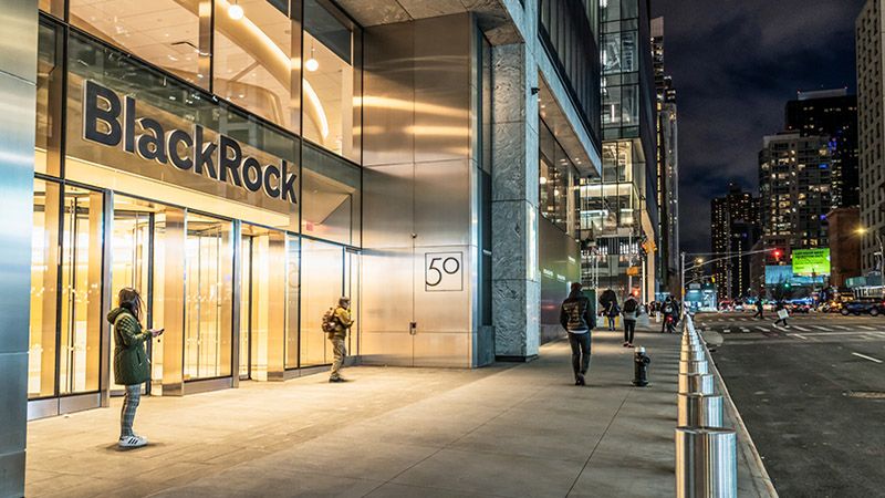 New York City, USA - People at night outside the entrance to BlackRock's headquarters office and on the street in Hudson Yards in Manhattan.