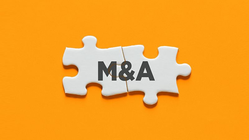 Connected puzzle pieces with the acronym M&A. Merger and acquisition in business concept.