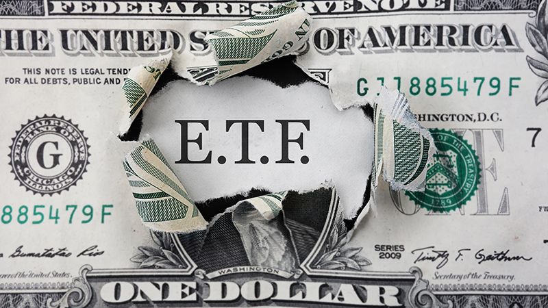 Torn dollar with ETF message, Exchange Traded Fund stock market concept